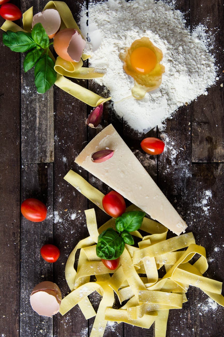 pasta tomatoes and flour with egg shells on table